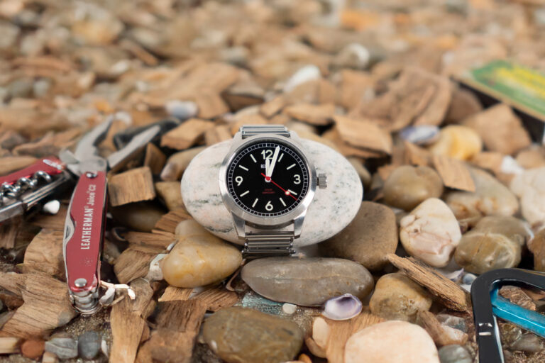 Watch surrounded by rocks and camping tools