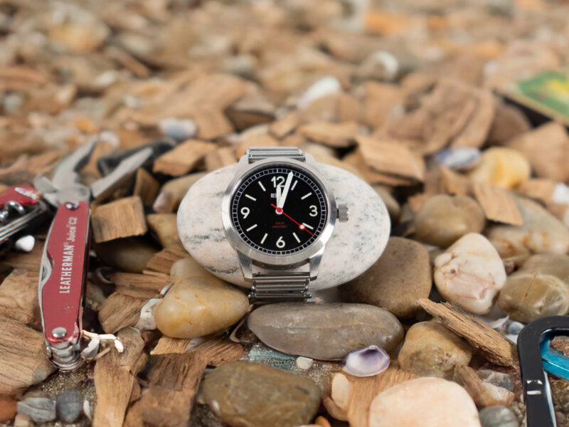 Watch surrounded by rocks and camping tools