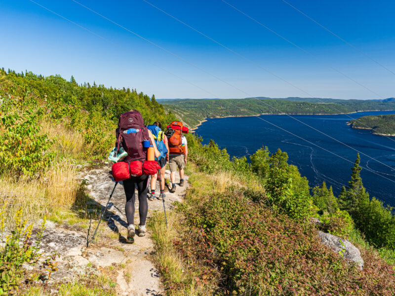 Saquenay Fjord Backpacking Group hiking on fjord ridge tops with water below to the right.