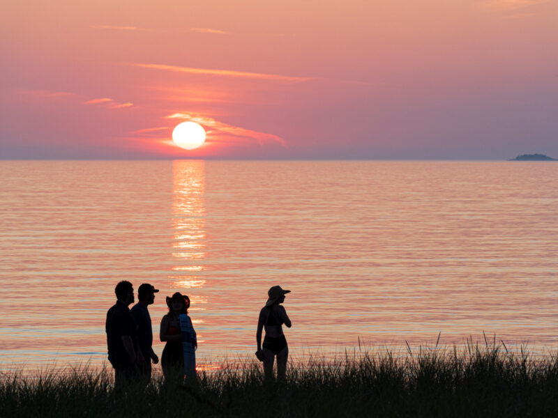 Lake Superior Sunset Silhouettes A group in silhouetteed against an orange sky watch the sun set over Lake Superior.