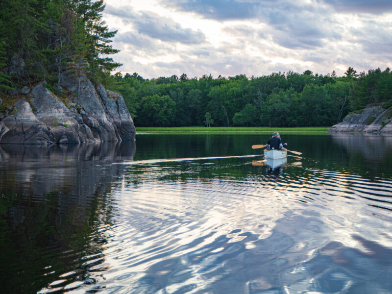 French River Evening Paddle Couple paddling in a calm in inlet in French River Provincial Park in the evening.